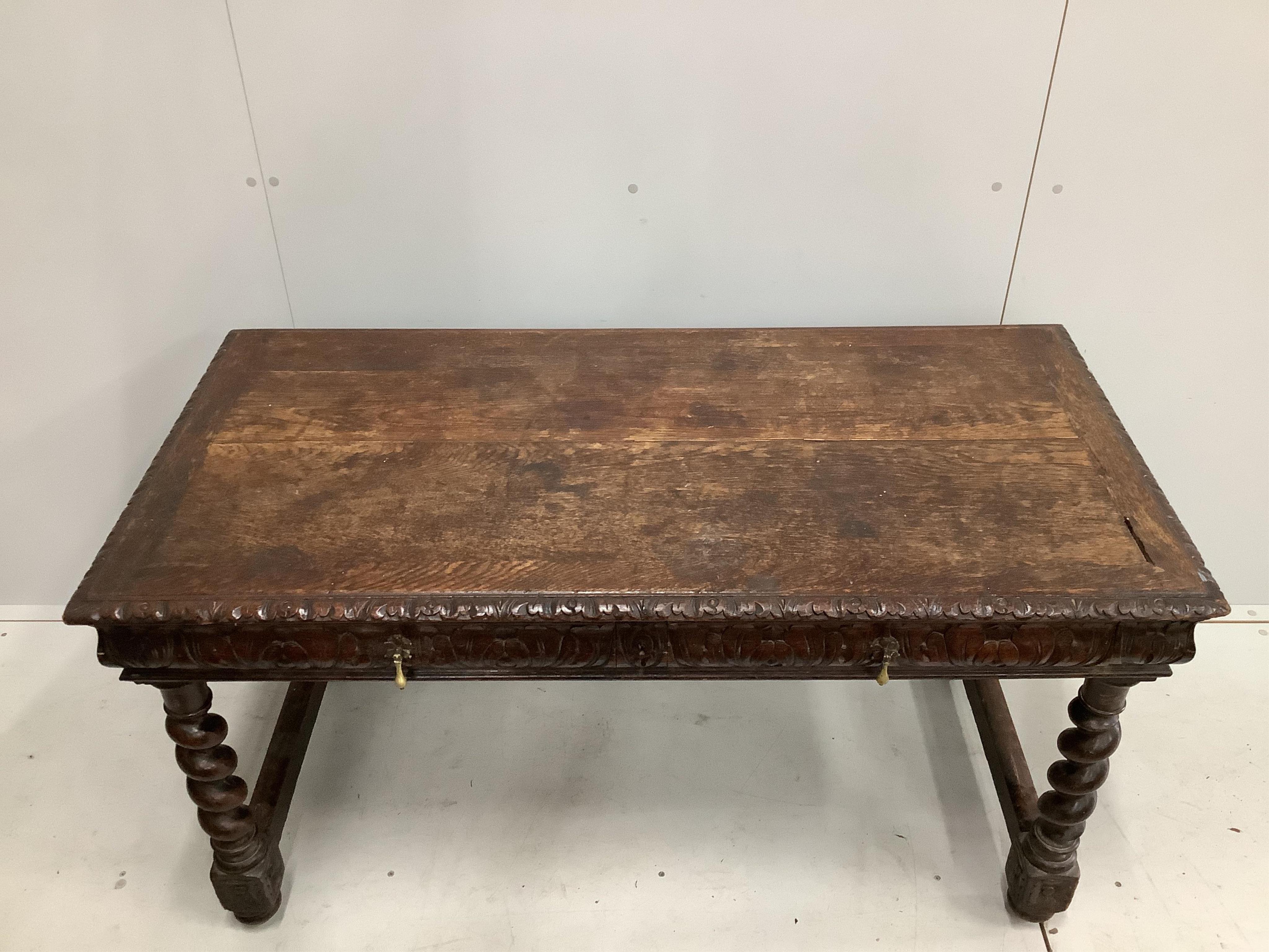 An early 20th century carved oak two drawer writing table, width 133cm, depth 67cm, height 72cm. Condition - fair